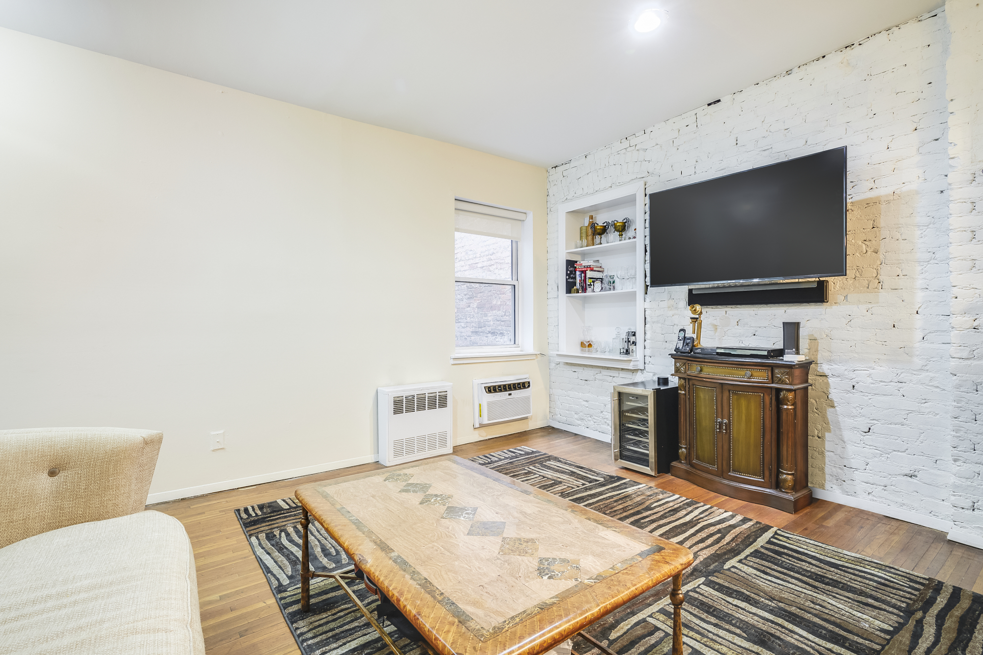 207 East 21st Street, Unit 5C Manhattan, NY 10010 - Photo 2 of 7 a living room with a flat screen tv and a fireplace