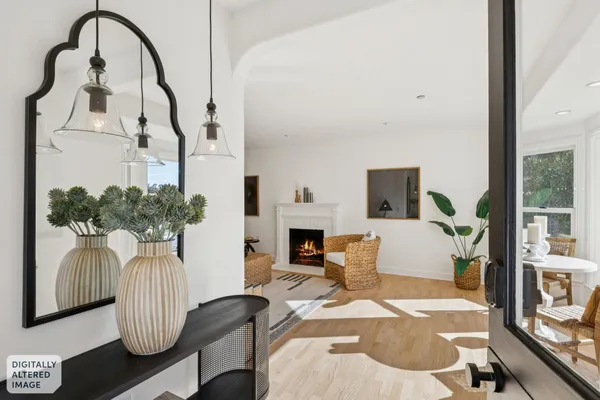a living room with furniture a fireplace and potted plants
