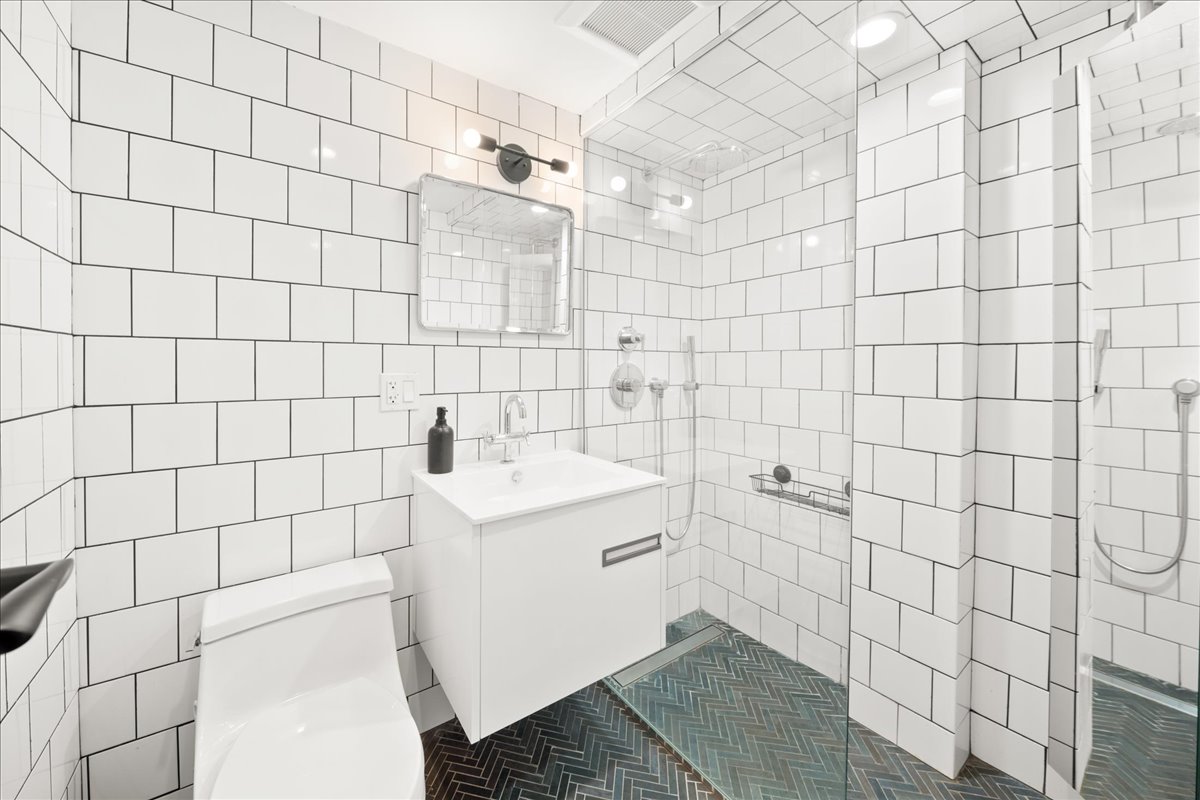 577 Madison Street, Unit 1B Brooklyn, NY 11221 - Photo 12 of 15 a bathroom with a sink toilet and shower