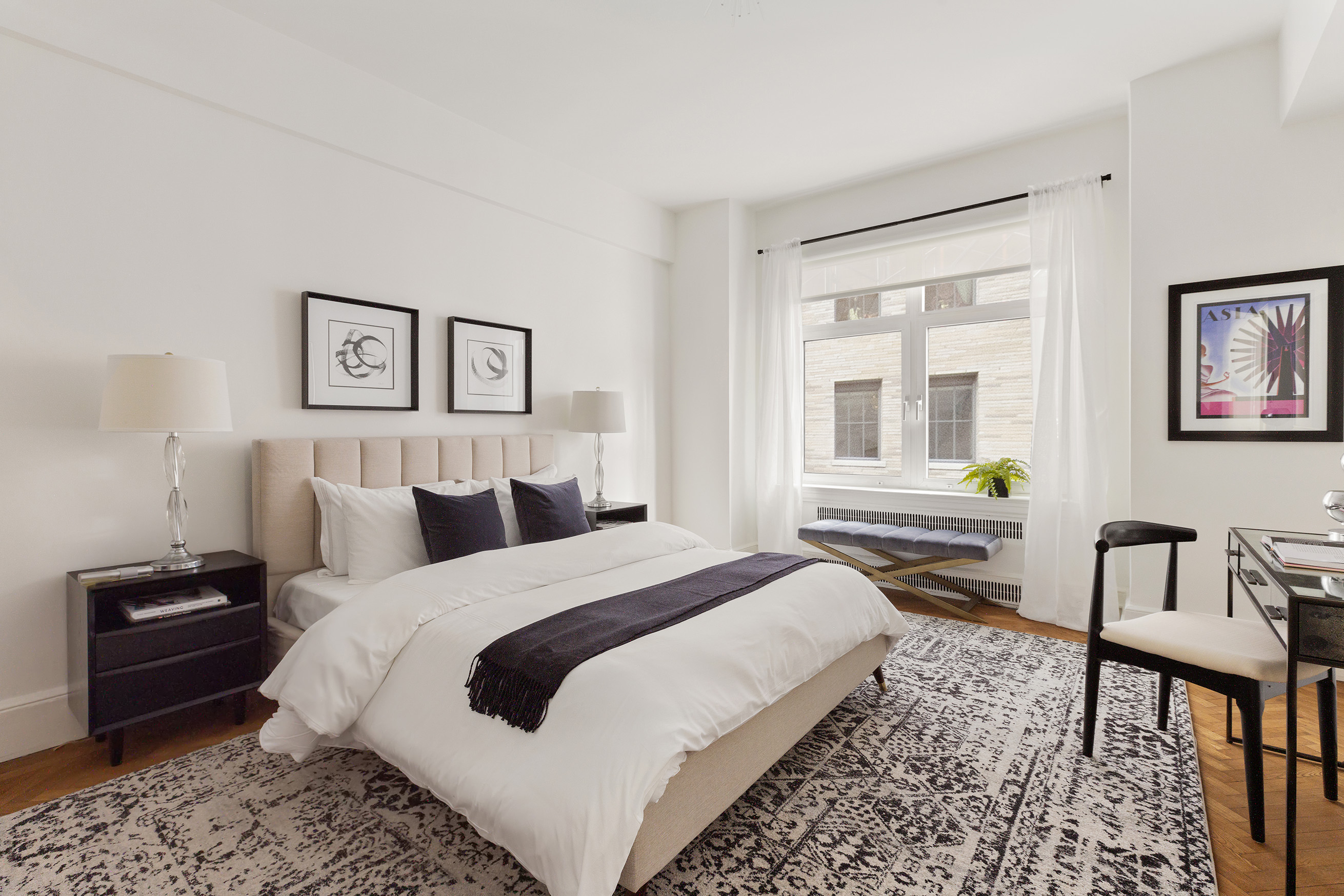 150 Central Park South, Unit 1010 Manhattan, NY 10019 - Photo 5 of 9 a bedroom with a bed a couch and a window