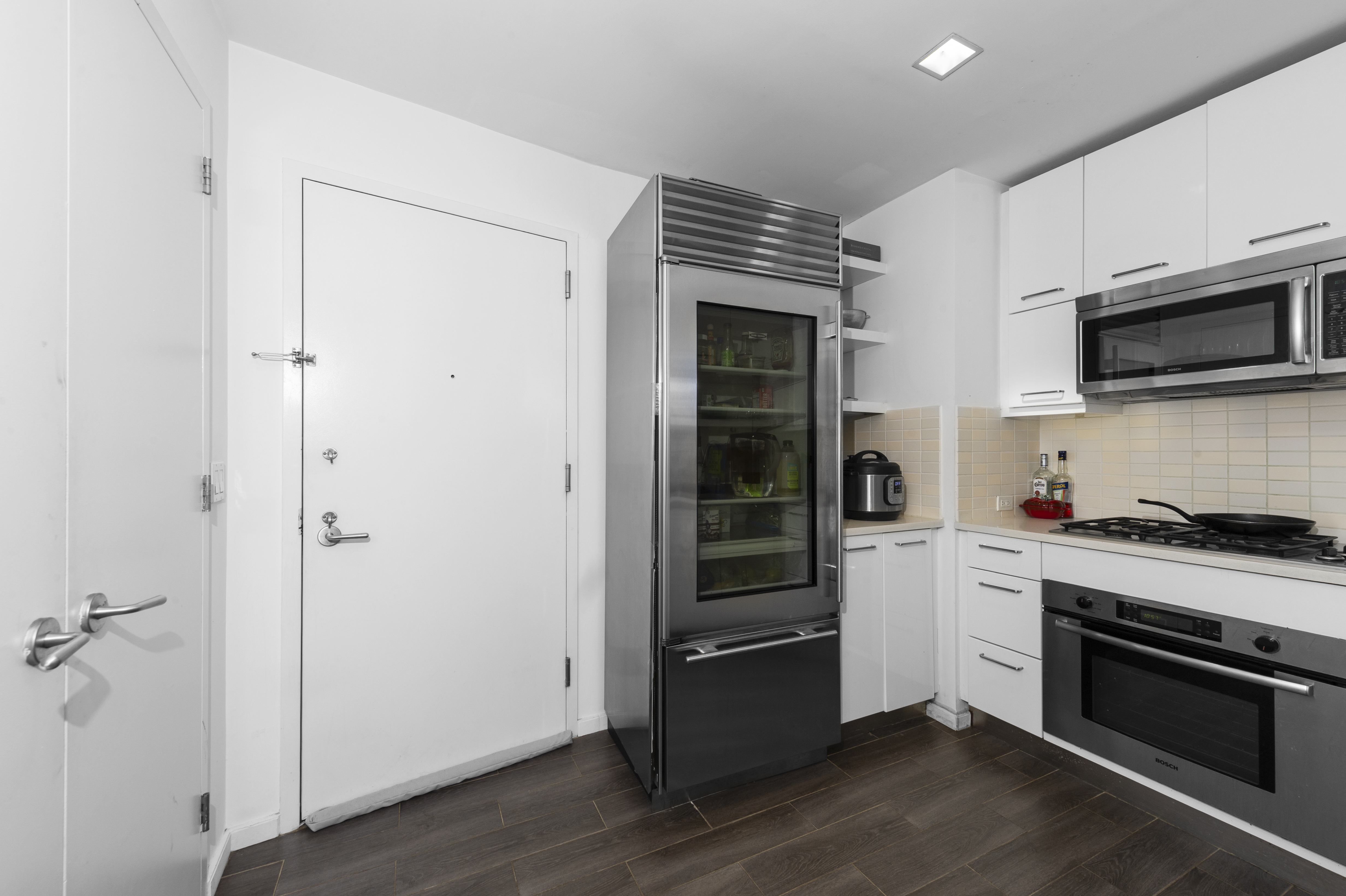 635 West 42nd Street, Unit 14K Manhattan, NY 10036 - Photo 11 of 19 a kitchen with granite countertop a stove and a refrigerator