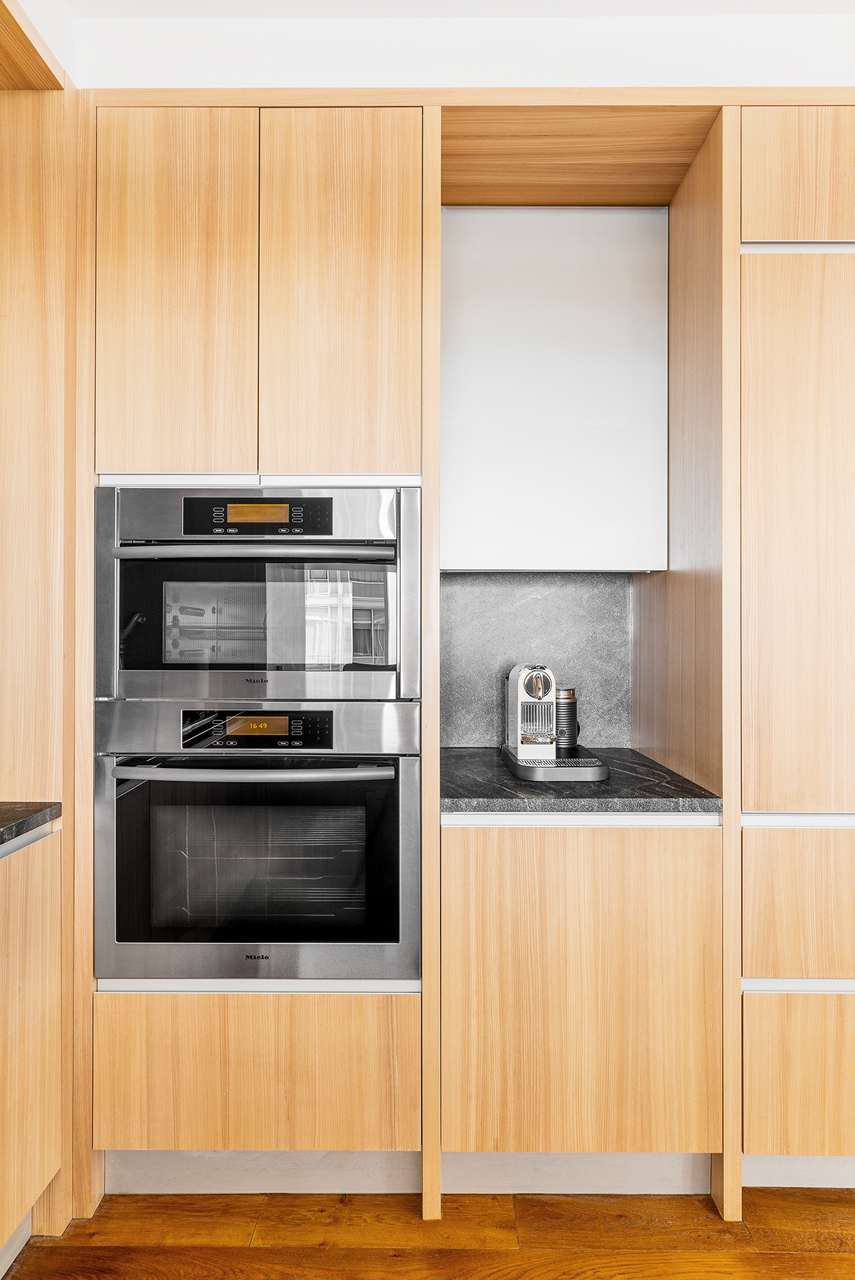 311 West Broadway, Unit 6J Manhattan, NY 10013 - Photo 7 of 19 a kitchen with stainless steel appliances granite countertop a stove and a microwave with wooden floor