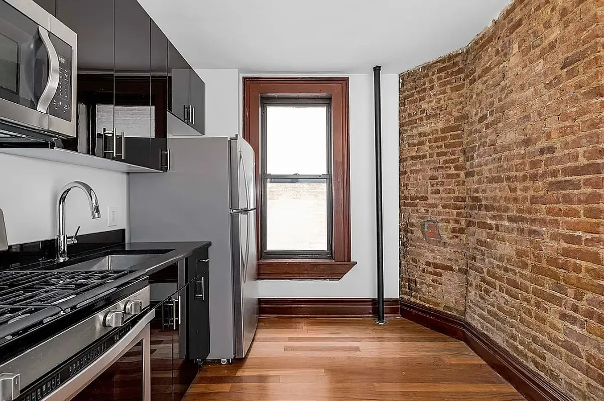 119 East 96th Street, Unit 20 Manhattan, NY 10128 - Photo 2 of 6 a view of a kitchen with wooden floor and a sink