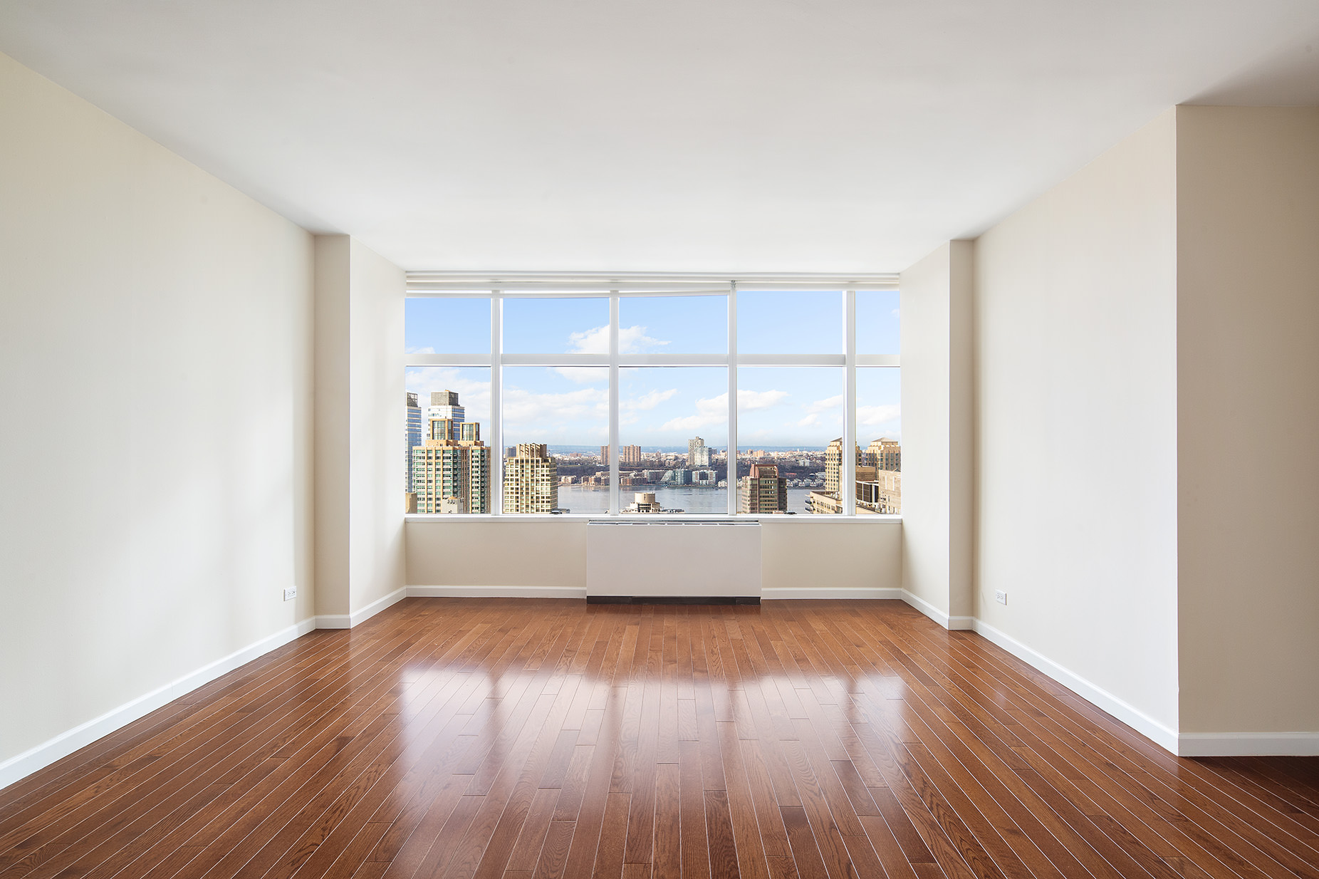 160 West 66th Street, Unit 33A Manhattan, NY 10023 - Photo 3 of 11 an empty room with wooden floor and windows