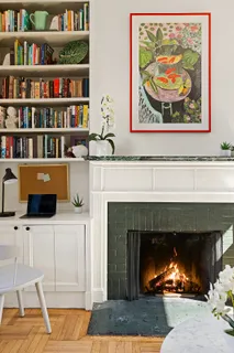 a living room with painting and a fireplace