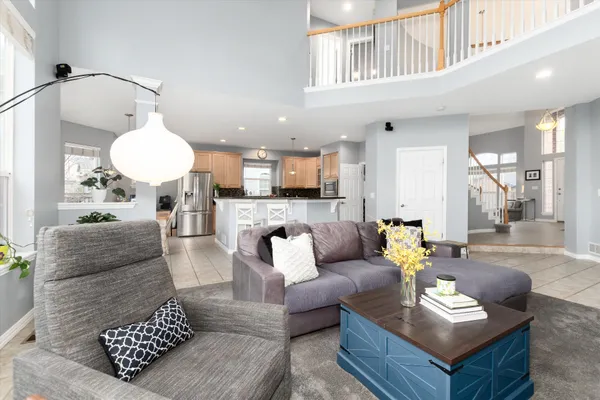 a kitchen with stainless steel appliances granite countertop a stove a refrigerator a kitchen island a table and chairs in it