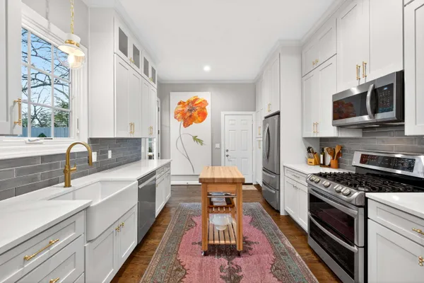 a kitchen with stainless steel appliances a stove a sink and a microwave