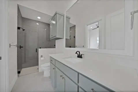 a bathroom with a sink a toilet and shower