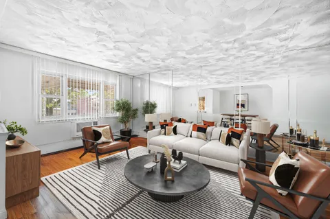 a living room with furniture a rug and a window