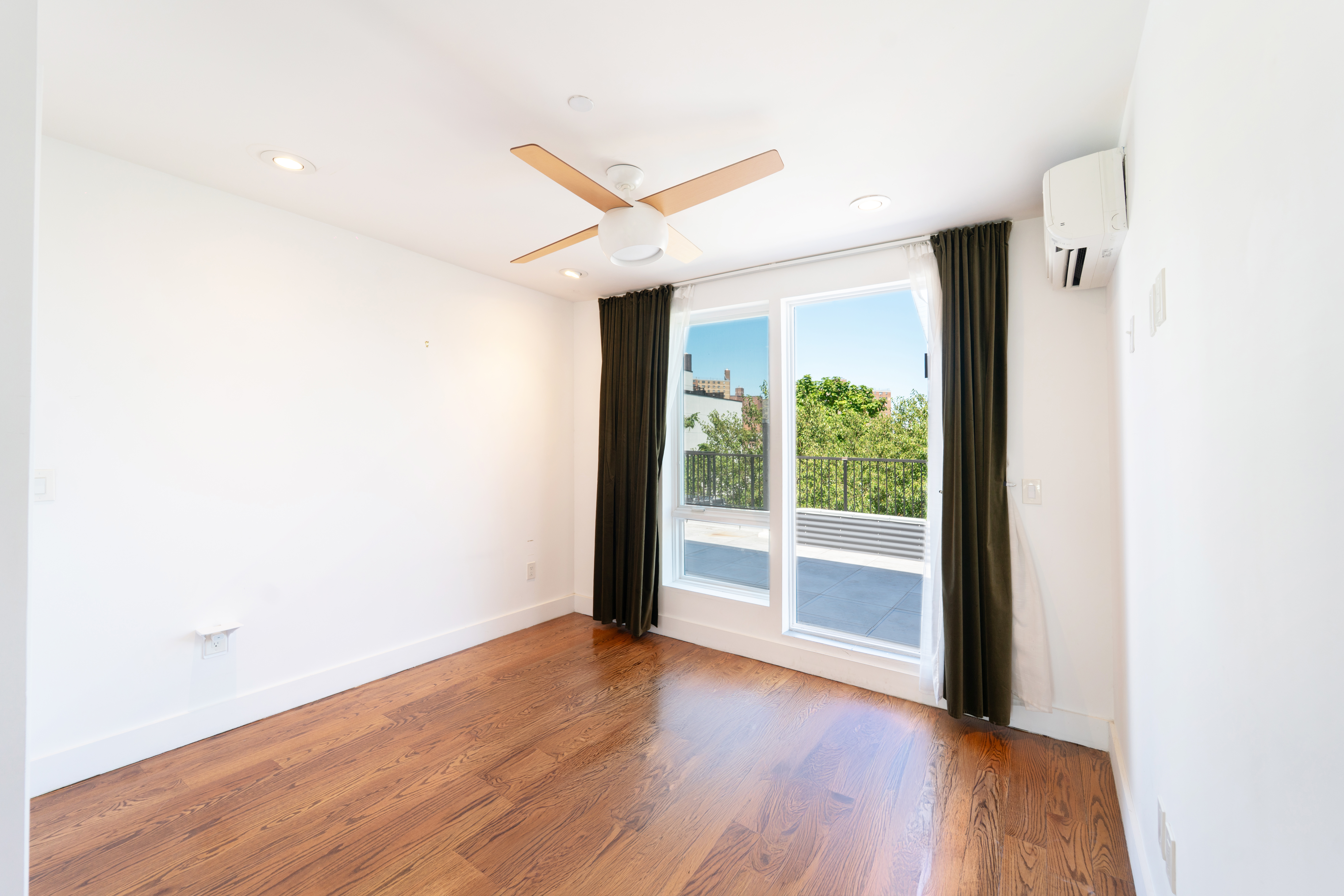 299 Van Buren Street, Unit 4C Brooklyn, NY 11221 - Photo 11 of 16 an empty room with wooden floor and windows