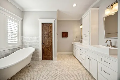 a spacious bathroom with double vanity a mirror a bathtub and a shower