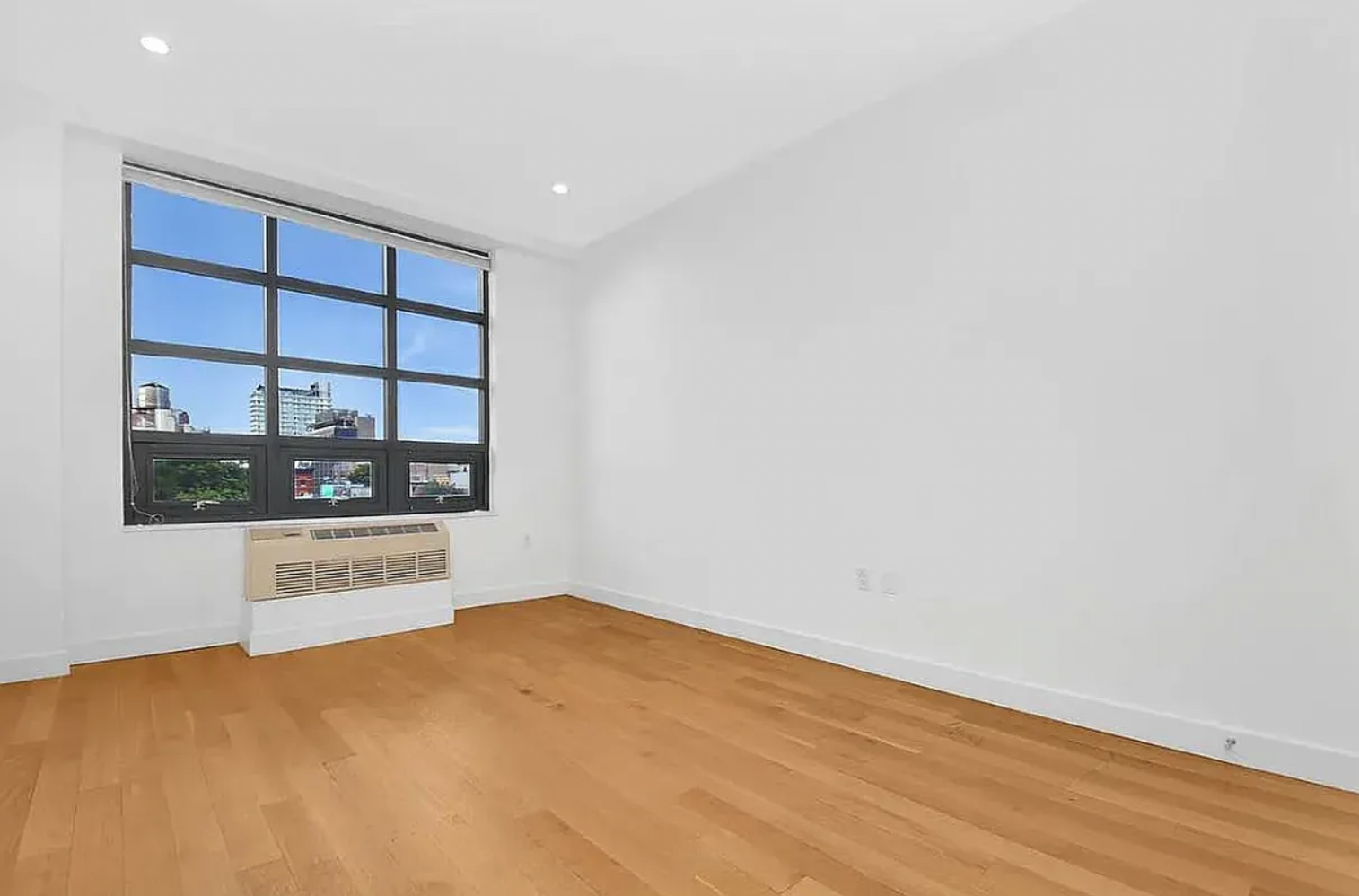 65 North 6th Street, Unit 3D Brooklyn, NY 11249 - Photo 2 of 7 a view of empty room with wooden floor and fan