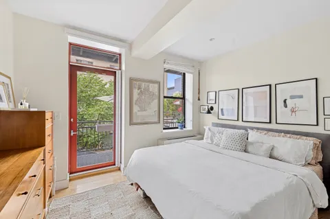 a bedroom with a large bed and a flat tv screen on dresser