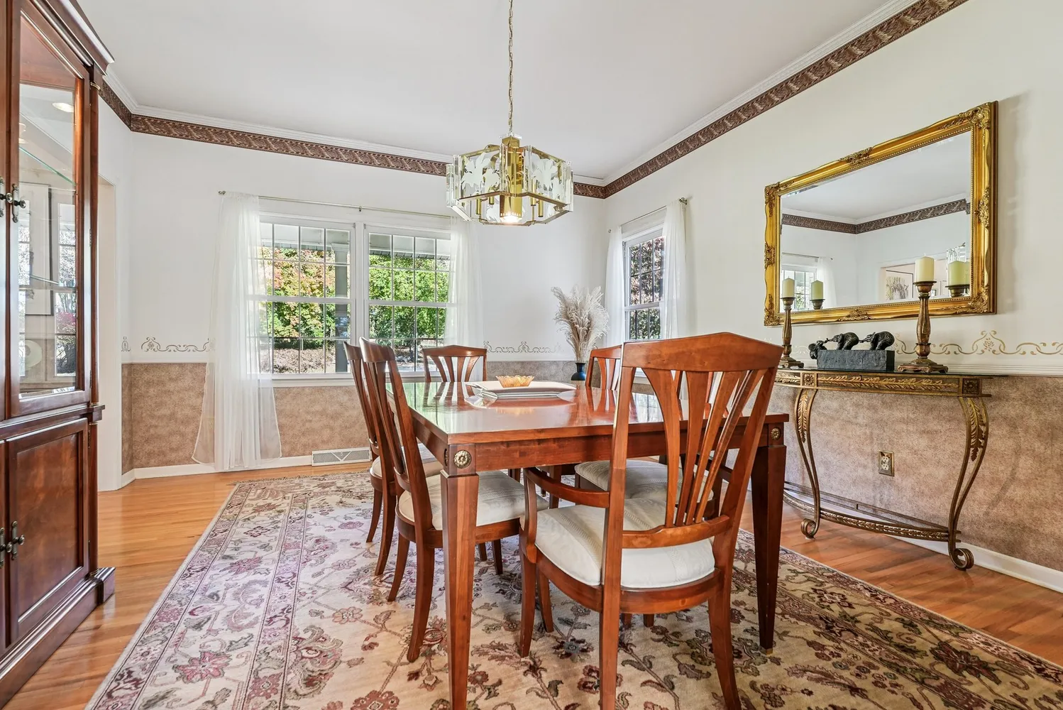 a dining room with furniture a chandelier and wooden floor