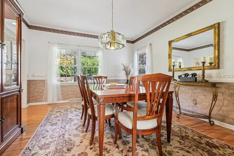 a dining room with furniture a chandelier and wooden floor