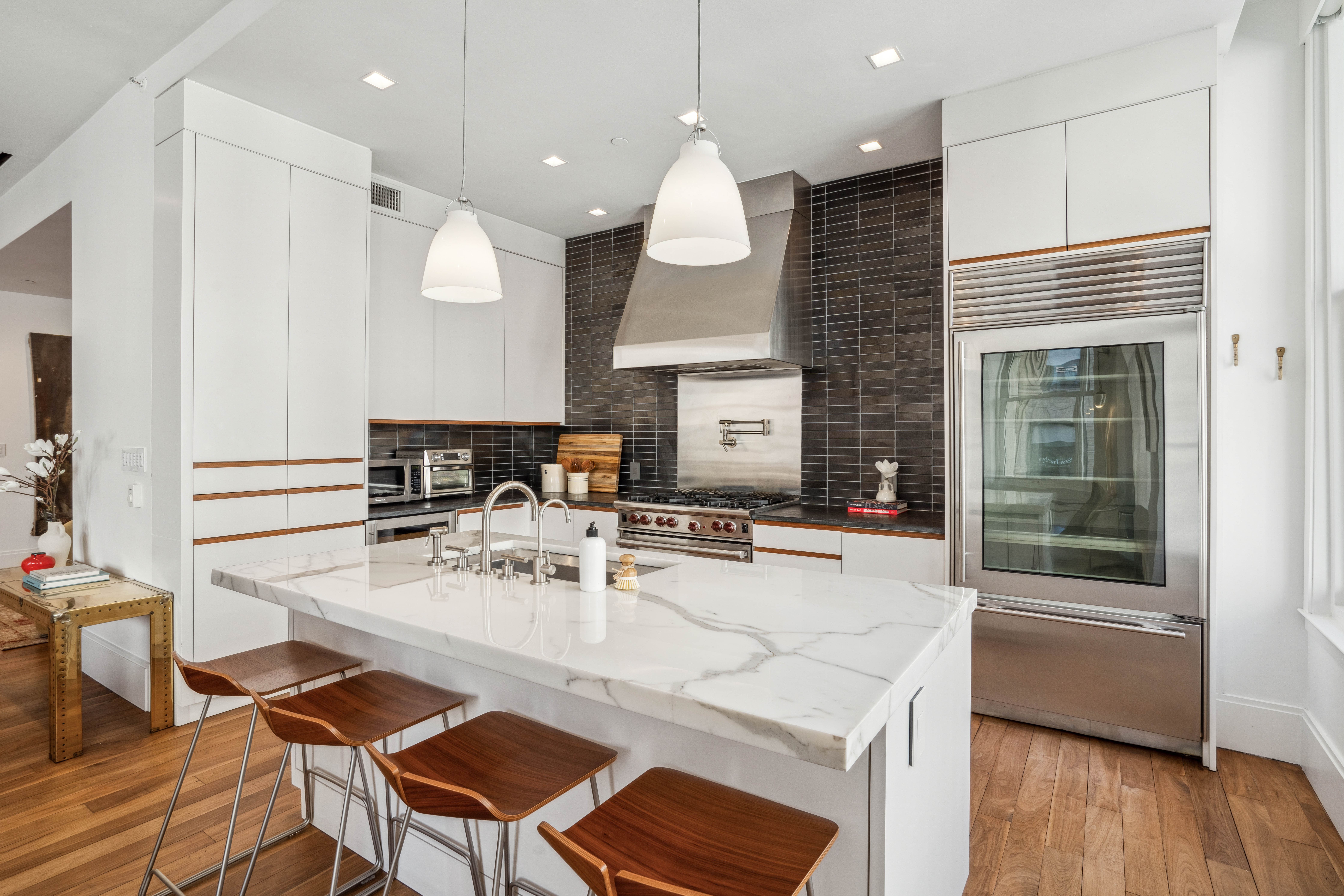 141 5th Avenue, Unit 4C Manhattan, NY 10010 - Photo 3 of 16 a dining room with stainless steel appliances kitchen island granite countertop a dining table chairs and couches
