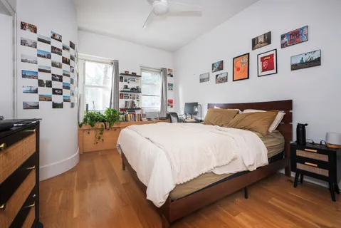 a bedroom with bed and wooden floor