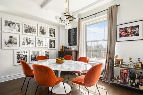 a view of a dining room with furniture a rug and wooden floor