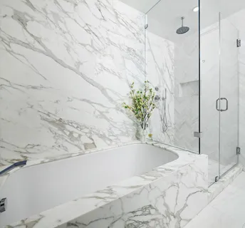 a white bath tub sitting in a bathroom and shower