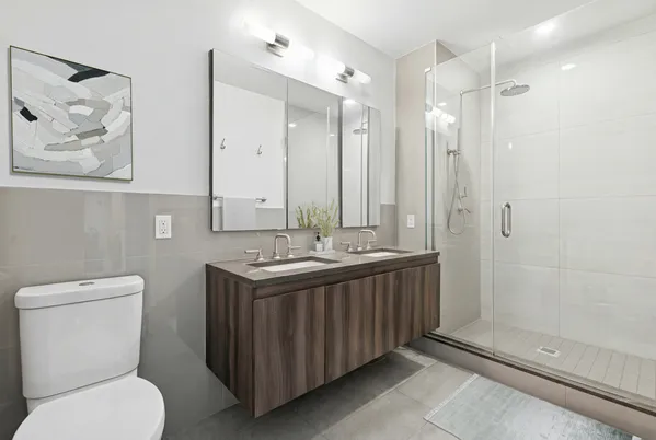 a bathroom with a double vanity sink mirror and toilet