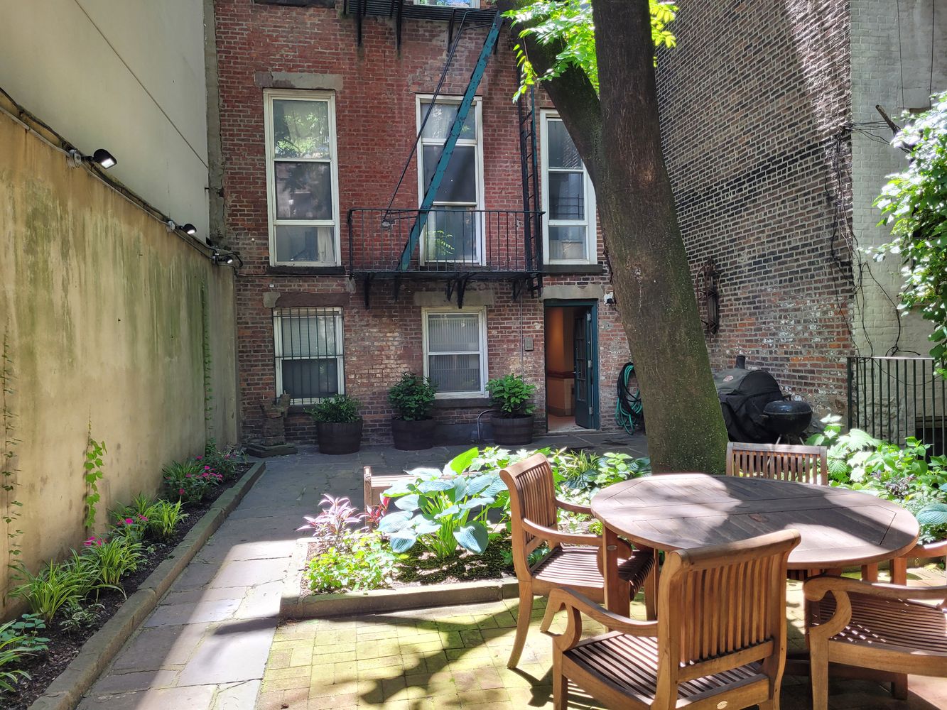 a view of a patio with table and chairs potted plants