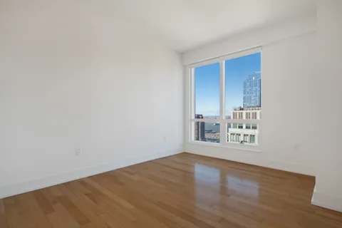 a view of a room with wooden floor and a window