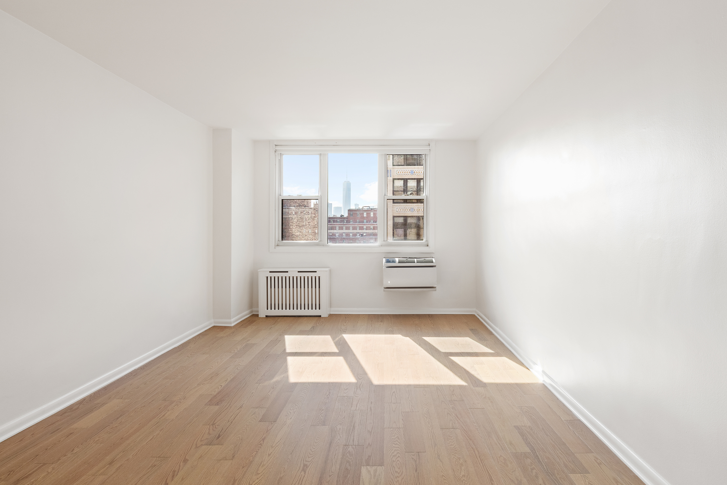 77 7th Avenue, Unit 12P Manhattan, NY 10011 - Photo 11 of 15 a view of a kitchen with wooden floor and electronic appliances