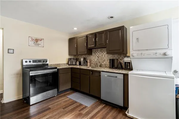 a kitchen with stainless steel appliances granite countertop a stove sink and cabinets