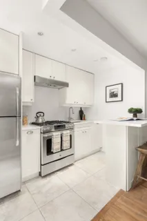 a kitchen with a stove top oven and refrigerator