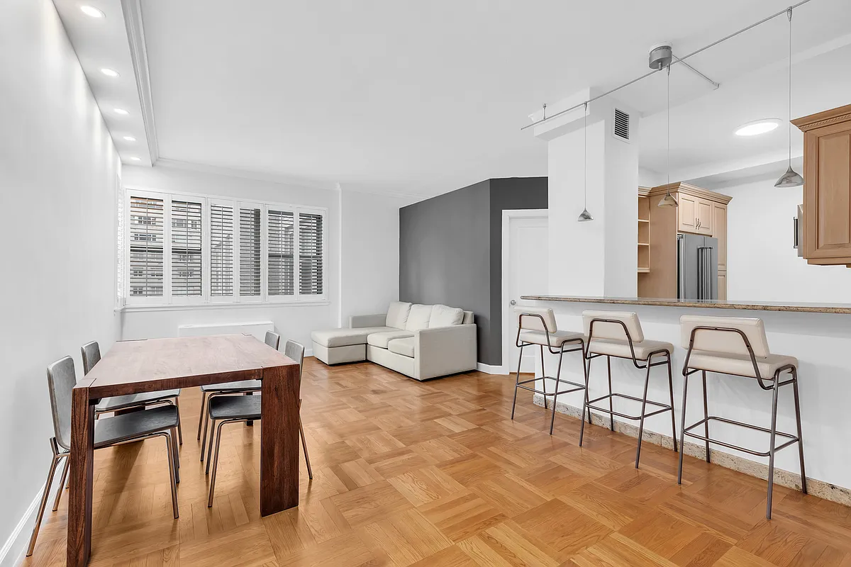 200 East 58th Street, Unit 15B Manhattan, NY 10022 - Photo 2 of 10 a living room with furniture a flat screen tv and a table