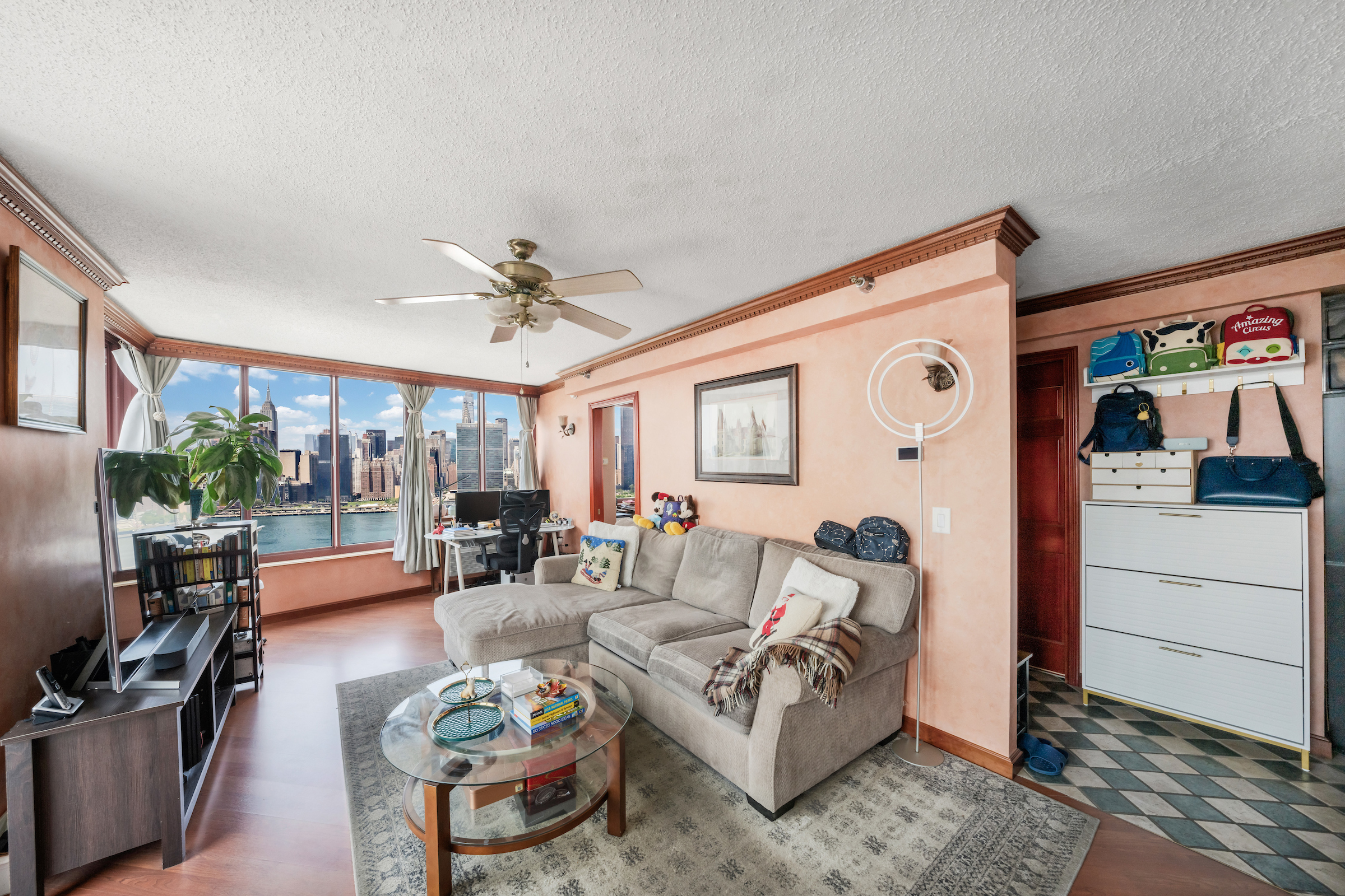 4-74 48th Avenue, Unit 27A Queens, NY 11109 - Photo 2 of 17 a living room with furniture and a large window