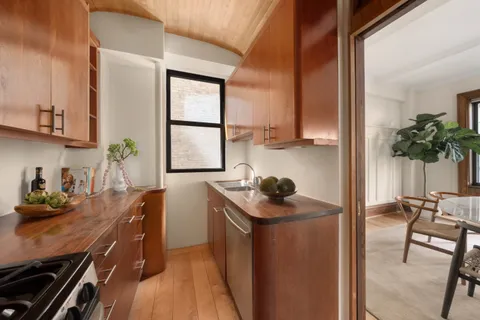 a kitchen with sink cabinets and stove top oven