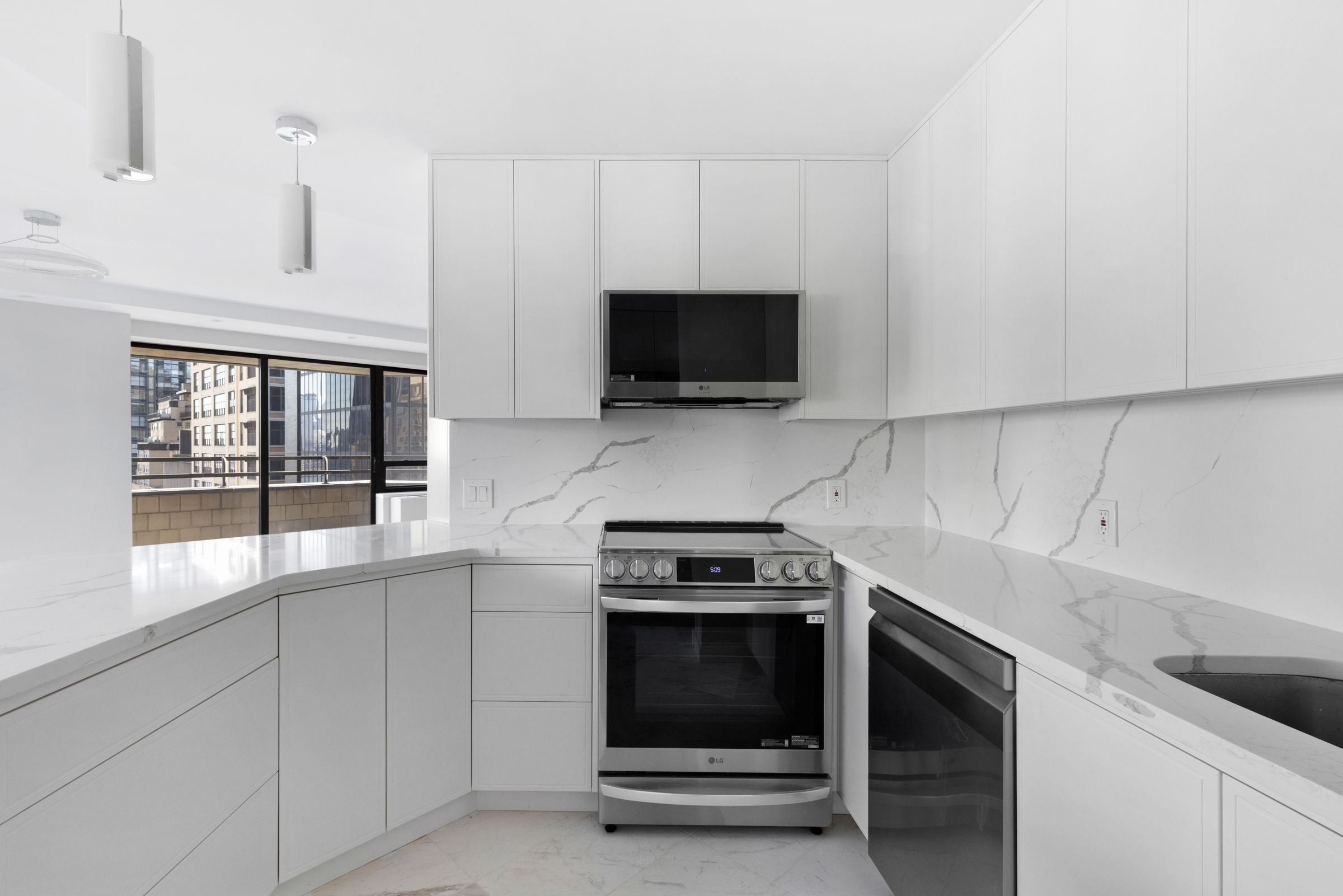 240 East 47th Street, Unit 16CD Manhattan, NY 10017 - Photo 5 of 12 a kitchen with a stove and a white cabinets