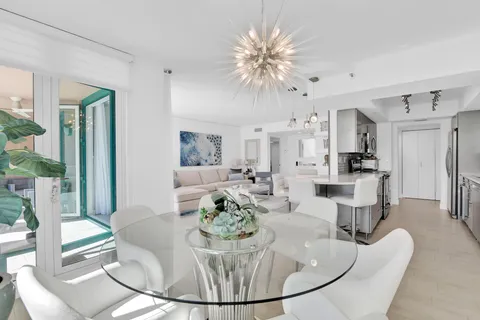 a living room with furniture a dining table and a chandelier