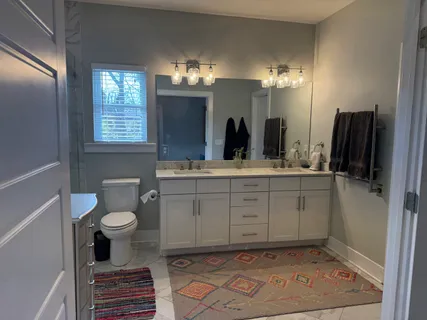 a bathroom with a sink a toilet a mirror and shower