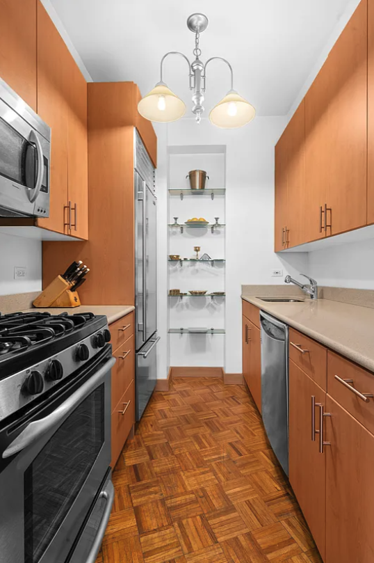 167 East 61st Street, Unit 21B Manhattan, NY 10065 - Photo 4 of 12 a kitchen with stainless steel appliances a stove and a microwave