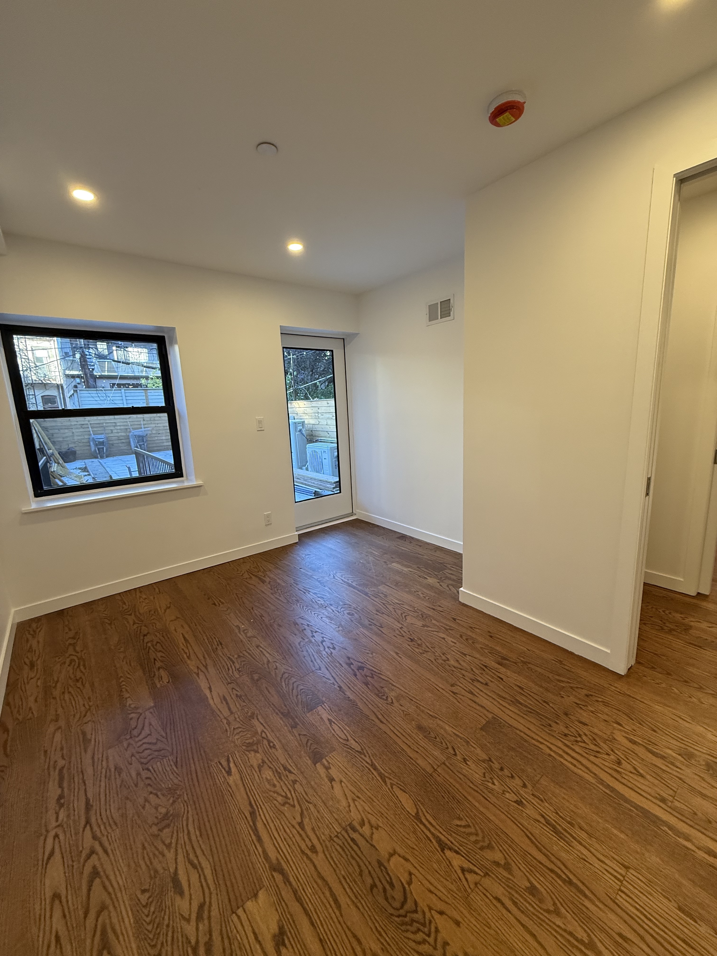 109 President Street, Unit 1 Brooklyn, NY 11231 - Photo 11 of 16 a view of an empty room with wooden floor and a window