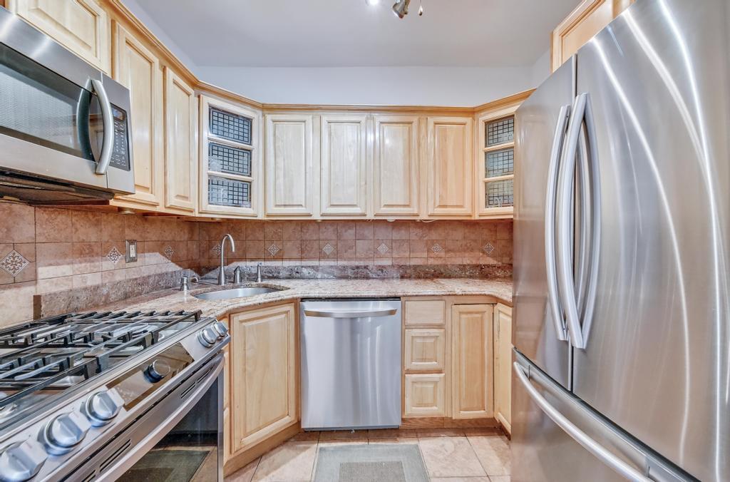 57 Carroll Street, Unit 38A Brooklyn, NY 11231 - Photo 14 of 21 a kitchen with stainless steel appliances granite countertop a stove a refrigerator and a microwave