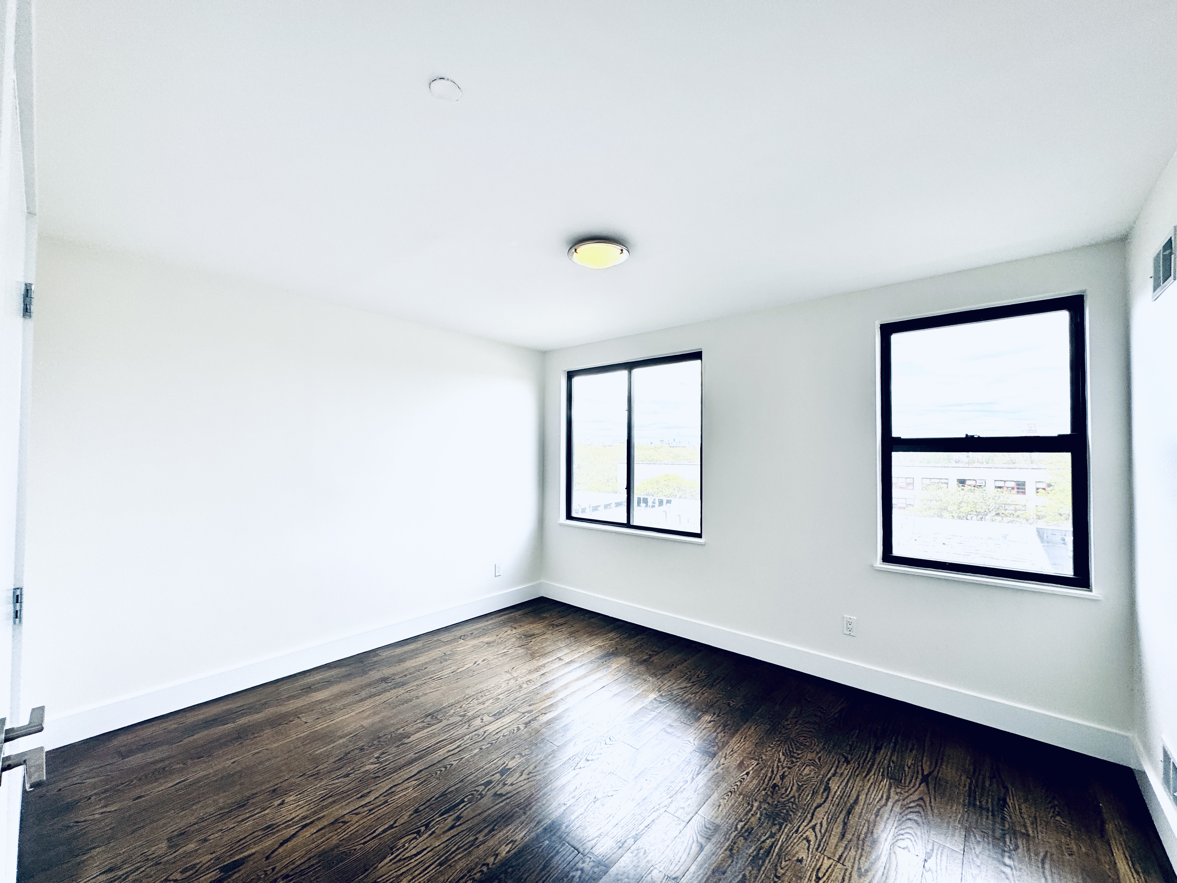 29 MacDougal Street, Unit 2 Brooklyn, NY 11233 - Photo 9 of 14 an empty room with wooden floor and windows