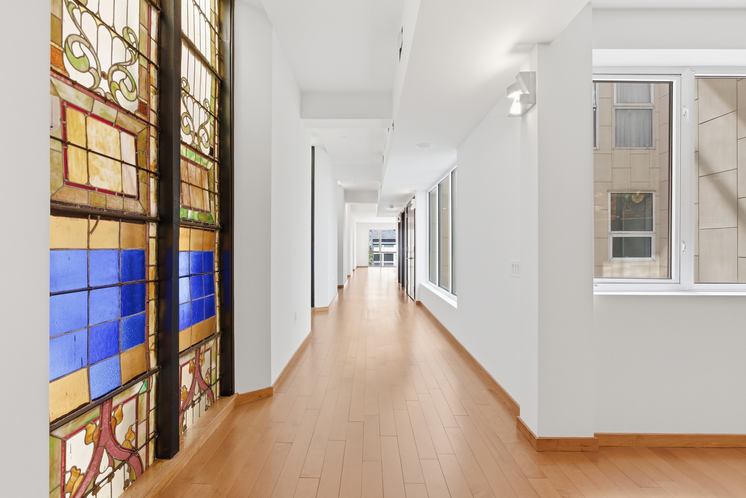135 West 4th Street, Unit 3W Manhattan, NY 10012 - Photo 5 of 24 a view of a hallway with wooden floor and windows