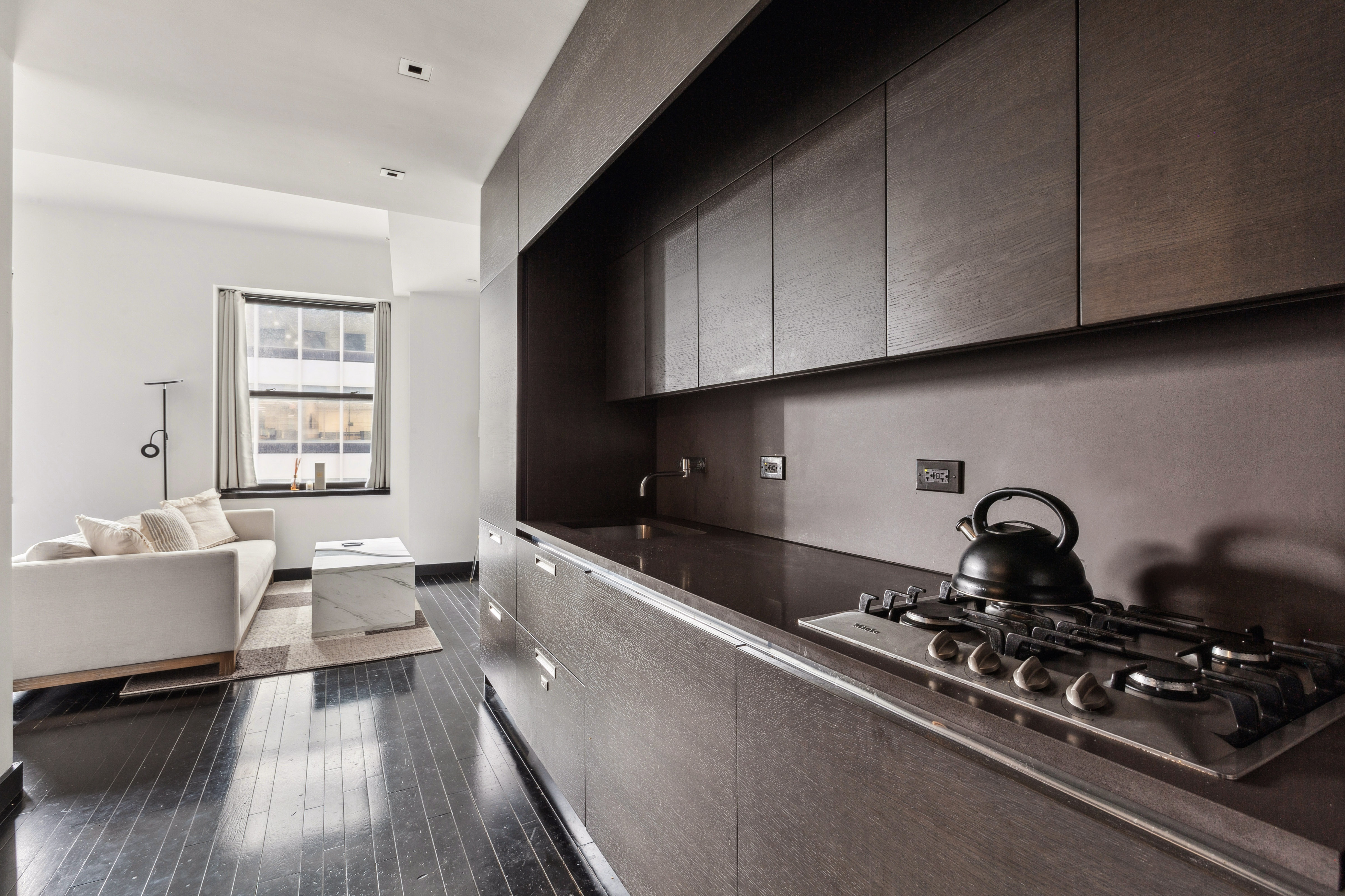 20 Pine Street, Unit 2905 Manhattan, NY 10005 - Photo 4 of 14 a kitchen with sink stove and cabinets