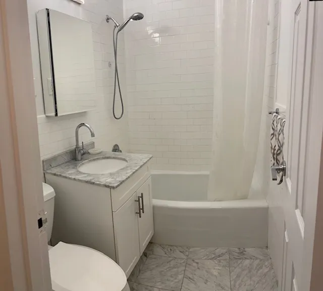 a bathroom with a granite countertop toilet a sink and a bathtub