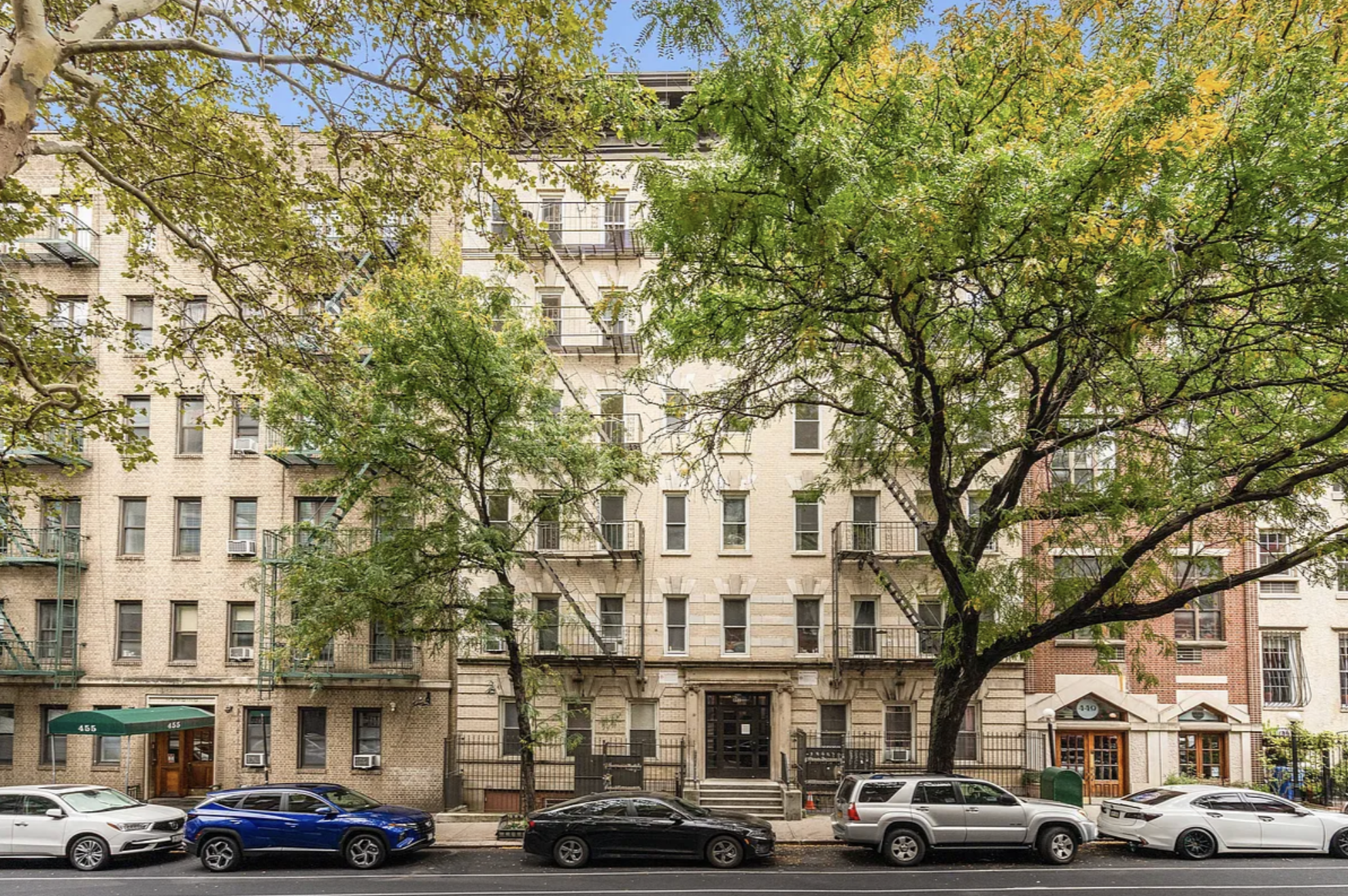 451 West 44th Street, Unit 5 Manhattan, NY 10036 - Photo 3 of 12 a front view of a building with lot of cars and trees