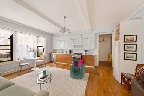 a living room with furniture and kitchen view