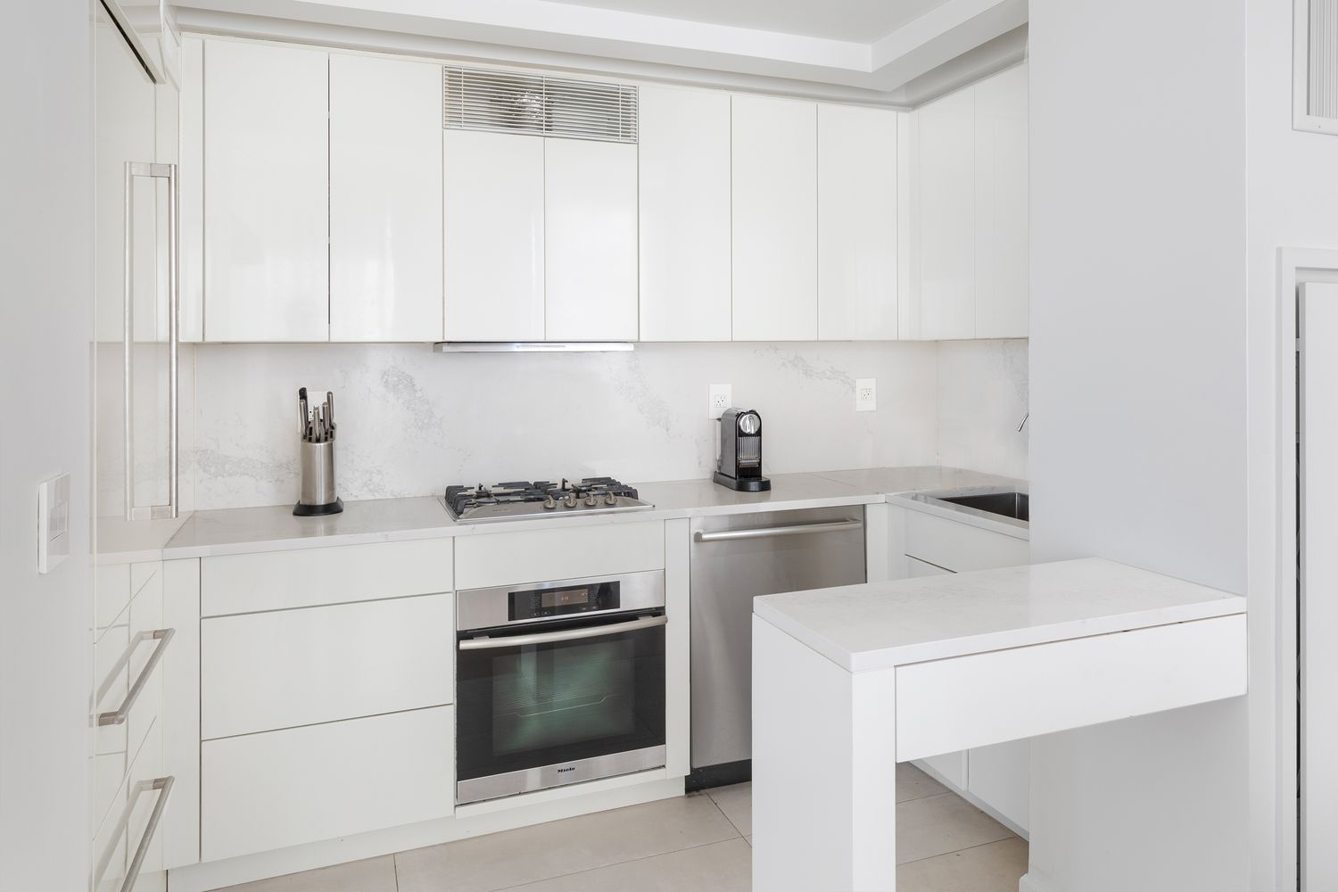 a kitchen with a stove and white cabinets