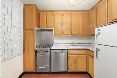 a kitchen with a refrigerator sink stove and cabinets