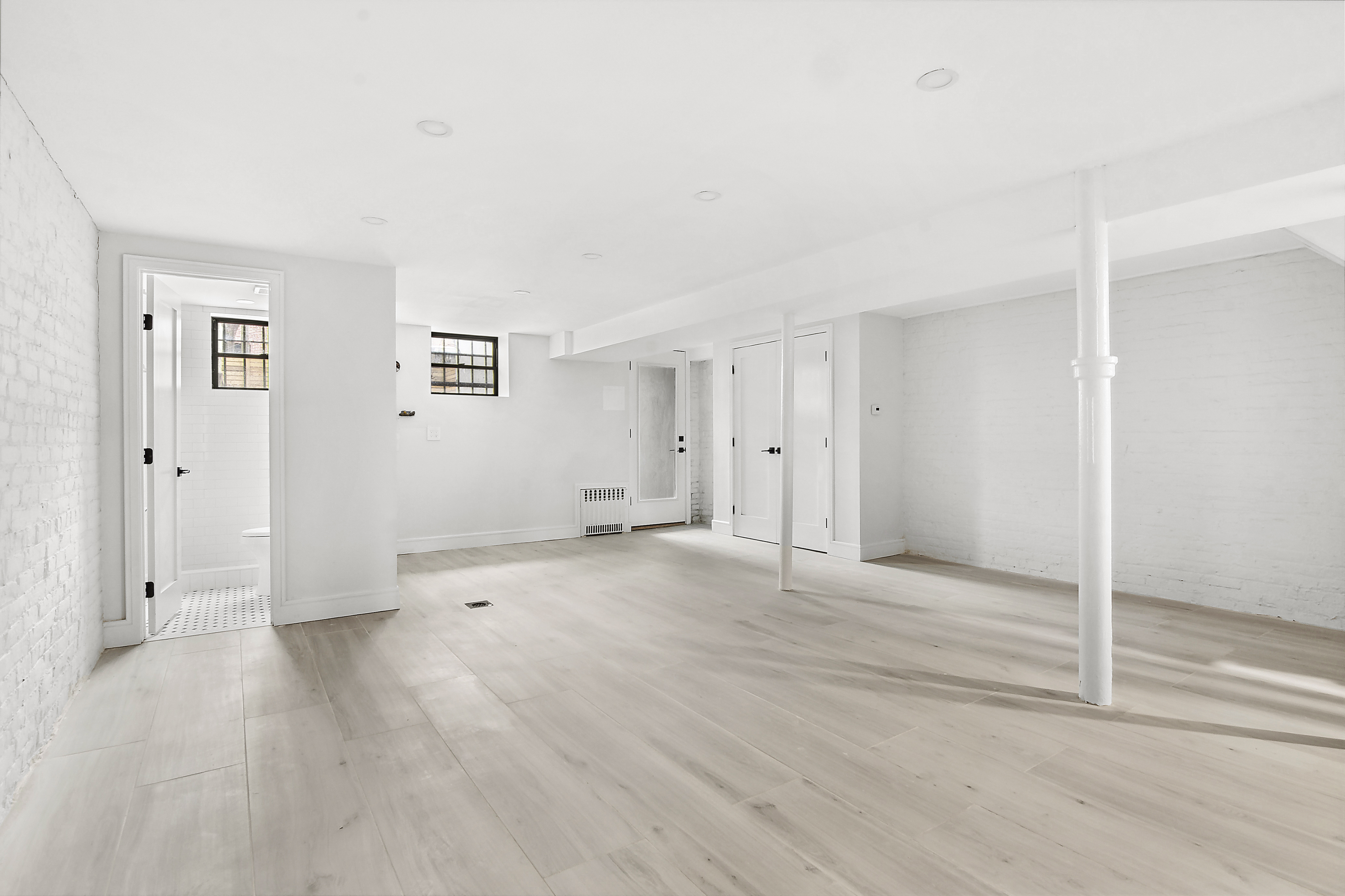 195 Rutland Road Brooklyn, NY 11225 - Photo 17 of 21 an empty room with wooden floor & windows