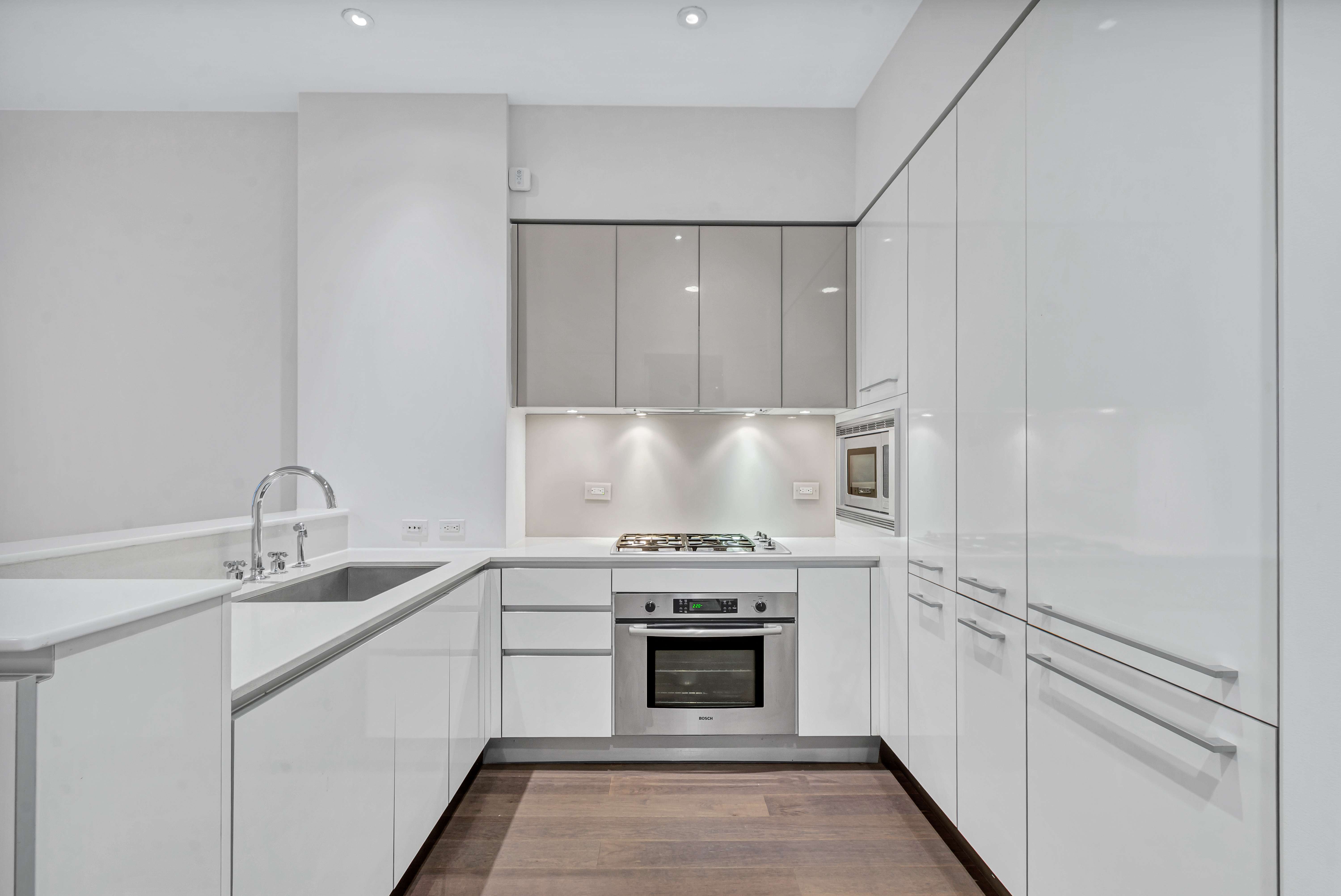 25 Broad Street, Unit 11K Manhattan, NY 10004 - Photo 4 of 16 a kitchen with a stove top oven and cabinets