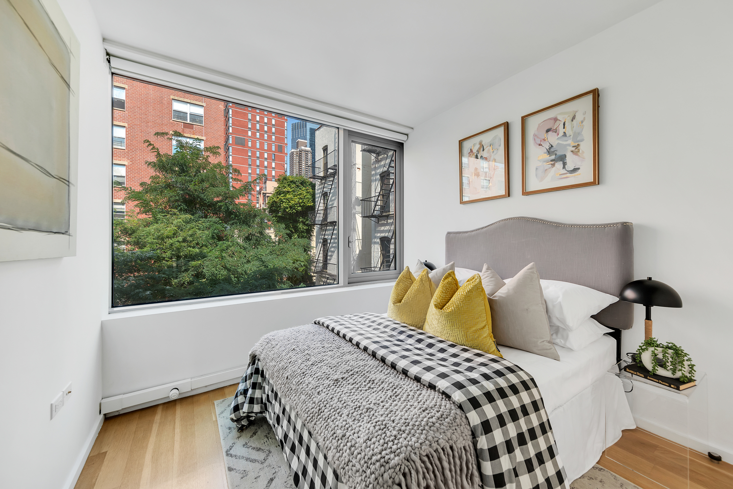 425 West 53rd Street, Unit 419 Manhattan, NY 10019 - Photo 9 of 18 a bedroom with a large bed and a large window