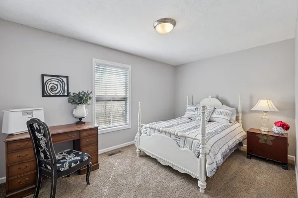 a bedroom with a bed chair and a window